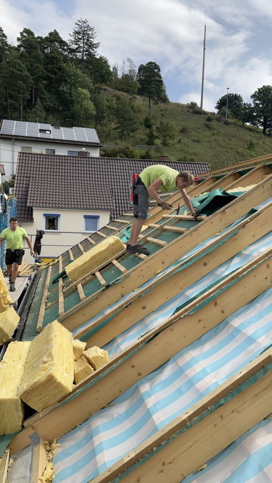 Mitarbeiter der Zimmerei & Holzbau Wiedmer sanieren ein Dach