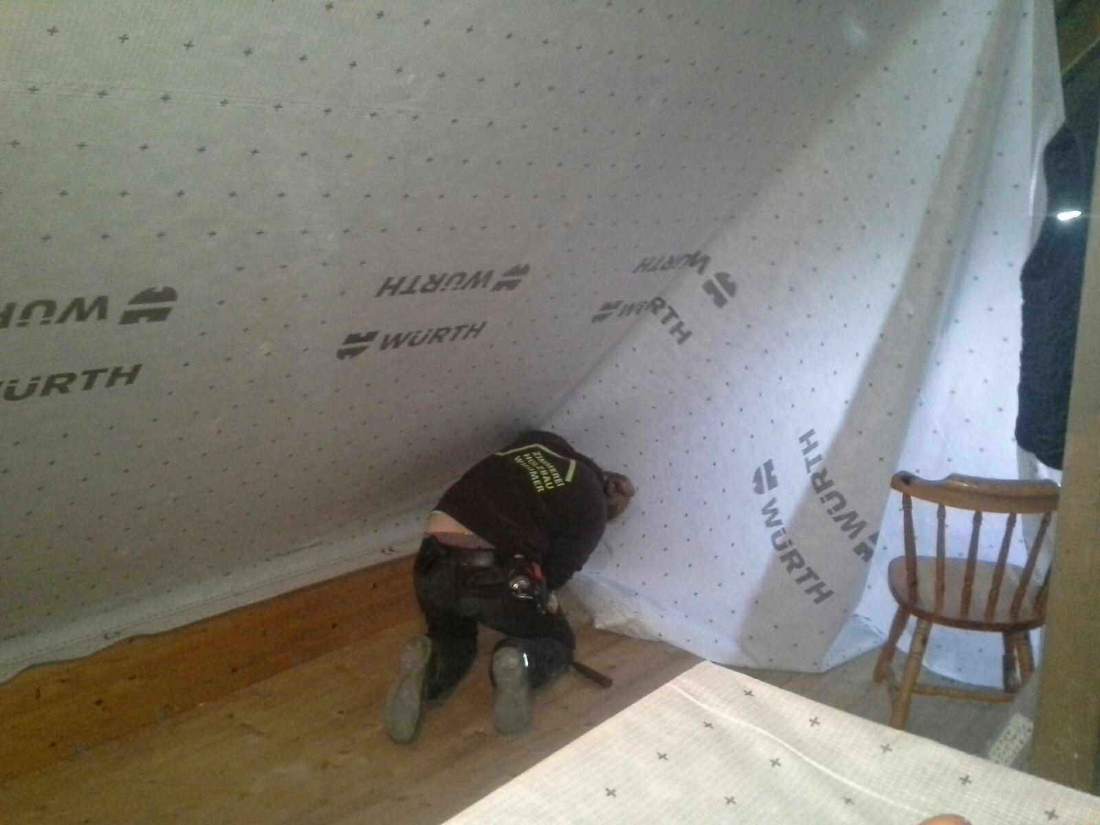 Ein Mitarbeiter der Zimmerei Wiedmer bringt eine Dampfbremse an